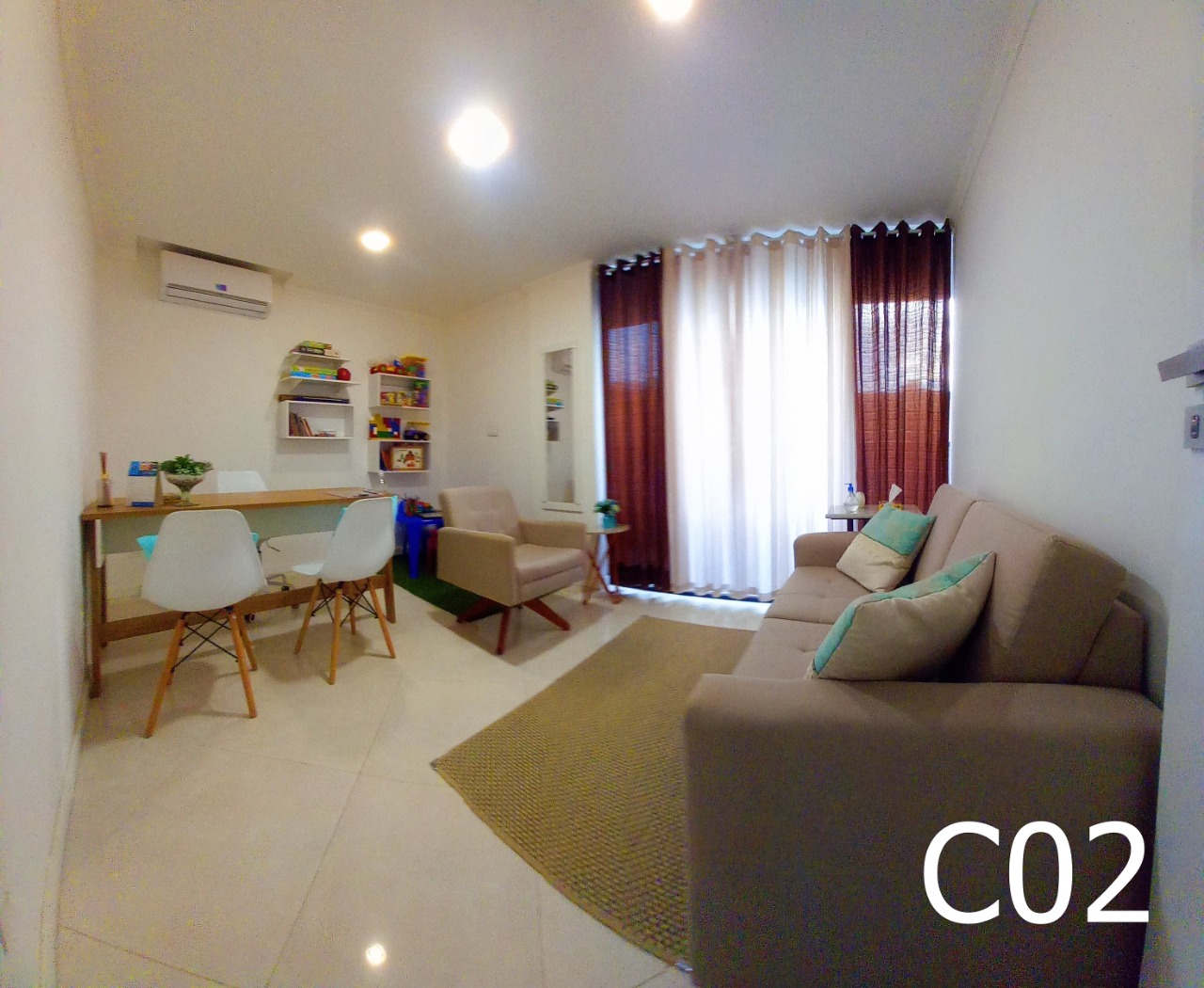 Sala de atendimento com sofá, mesa e cortinas